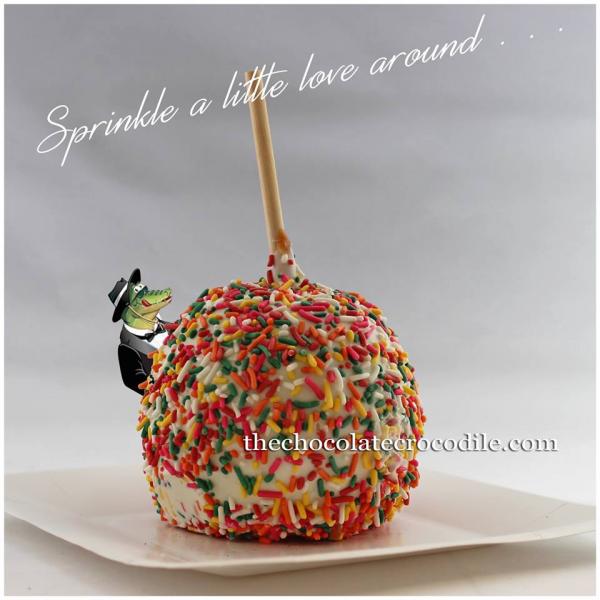 Satiate your sweet tooth with a sweet apple dipped in white chocolate and covered with sprinkles. 